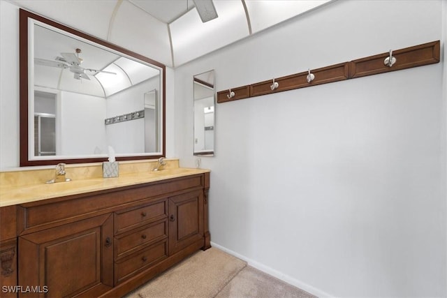 full bath with ceiling fan, double vanity, baseboards, and a sink