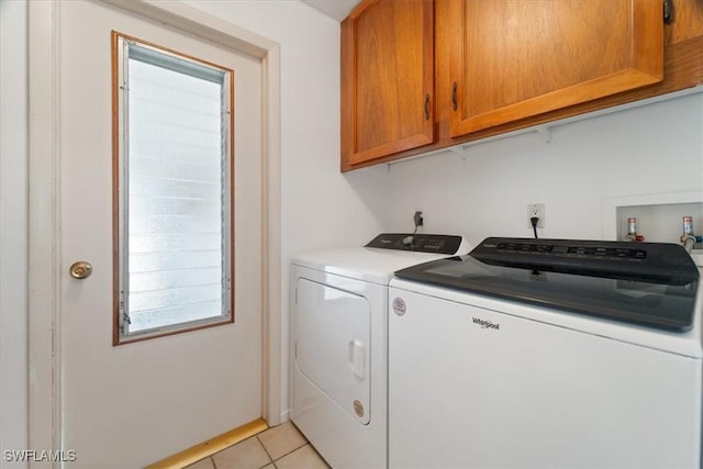 washroom with light tile patterned floors, cabinet space, and independent washer and dryer