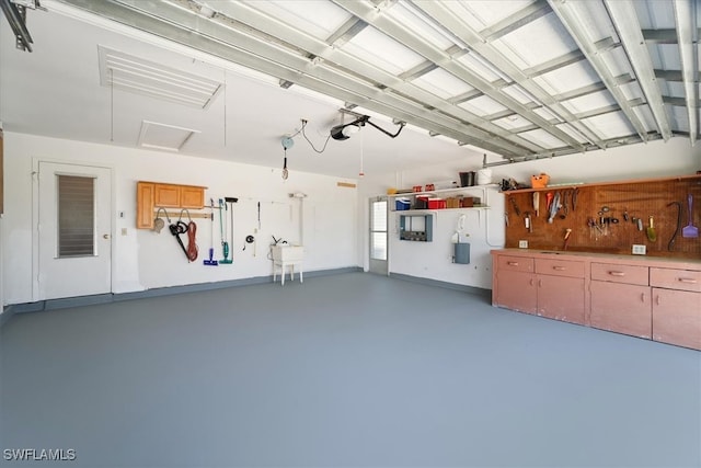 garage with a sink, a workshop area, and a garage door opener