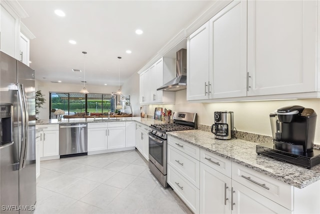 4360 Aurora St, Naples, FL 34119 - kitchen with stainless steel appliances, wall chimney exhaust hood, recessed lighting, white cabinetry, and decorative light fixtures