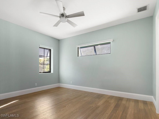 unfurnished room featuring visible vents, ceiling fan, baseboards, and wood finished floors