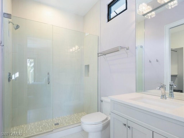 bathroom featuring vanity, a shower stall, and toilet