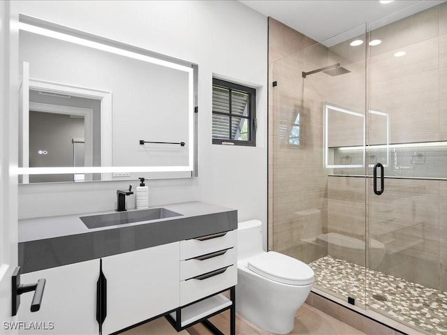 full bathroom featuring a shower stall, toilet, and vanity