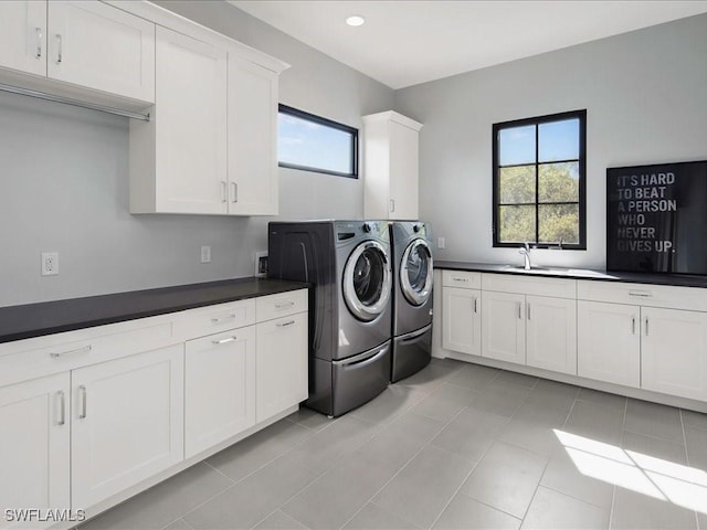 laundry area with a sink, cabinet space, independent washer and dryer, and light tile patterned floors