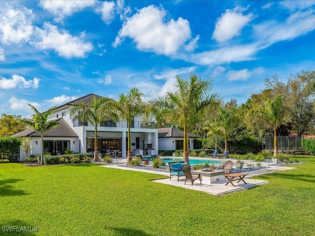 back of house with a patio area, a lawn, and an outdoor pool