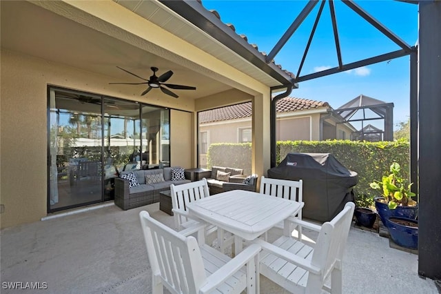 view of patio / terrace featuring area for grilling, an outdoor living space, glass enclosure, and ceiling fan