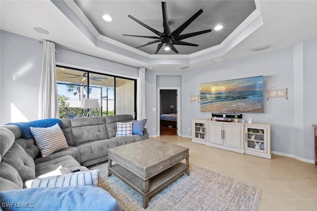 living area with light tile patterned flooring, visible vents, a raised ceiling, and ceiling fan