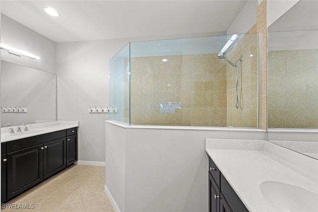 full bathroom featuring baseboards, two vanities, a tile shower, a sink, and tile patterned flooring