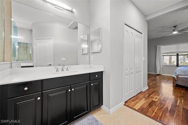 bathroom with vanity, wood finished floors, a ceiling fan, and baseboards