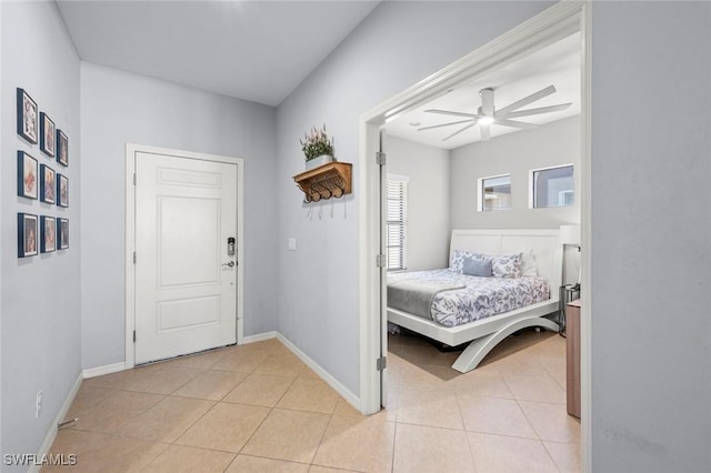 interior space with light tile patterned floors, ceiling fan, and baseboards