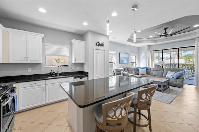 kitchen featuring open floor plan, light tile patterned flooring, stainless steel appliances, and a sink