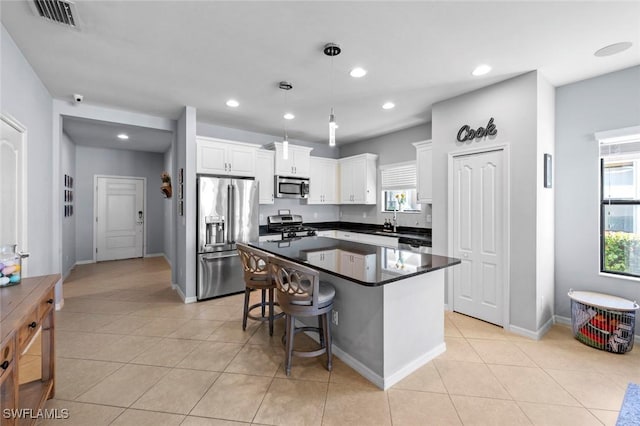 kitchen featuring light tile patterned floors, visible vents, white cabinets, appliances with stainless steel finishes, and dark countertops