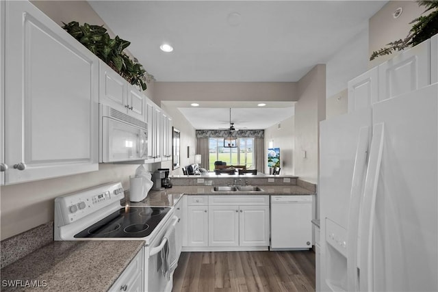 kitchen featuring recessed lighting, dark wood-type flooring, white cabinets, a sink, and white appliances