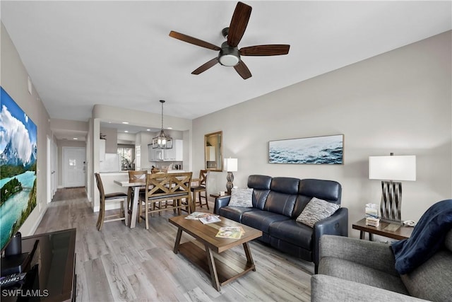 living area with light wood finished floors and ceiling fan