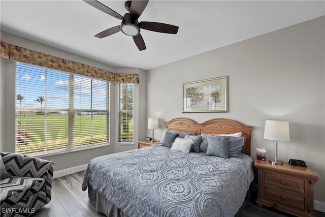 bedroom featuring ceiling fan, baseboards, and wood finished floors