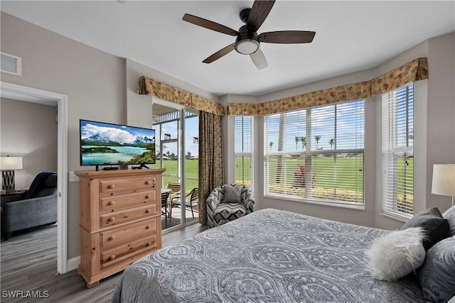 bedroom featuring a ceiling fan, access to outside, visible vents, and wood finished floors