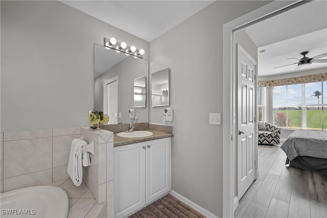 bathroom featuring a bathtub, ceiling fan, vanity, ensuite bath, and wood finished floors