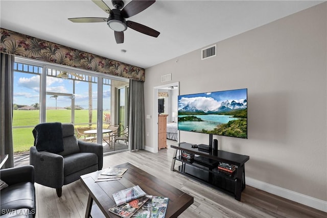 living area featuring light wood-style flooring, visible vents, and baseboards