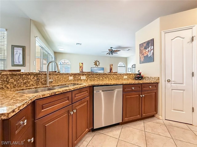 kitchen with visible vents, light stone countertops, dishwasher, light tile patterned floors, and a sink