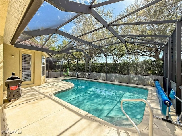 view of swimming pool with a patio area, a fenced in pool, and glass enclosure