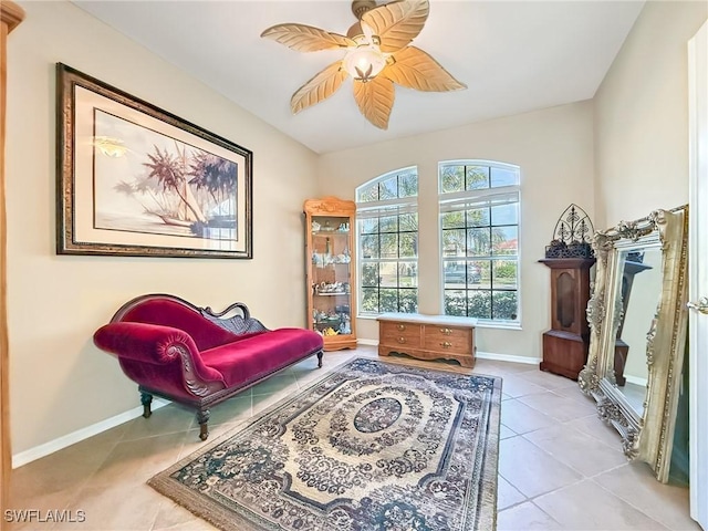 living area with tile patterned flooring, baseboards, and ceiling fan