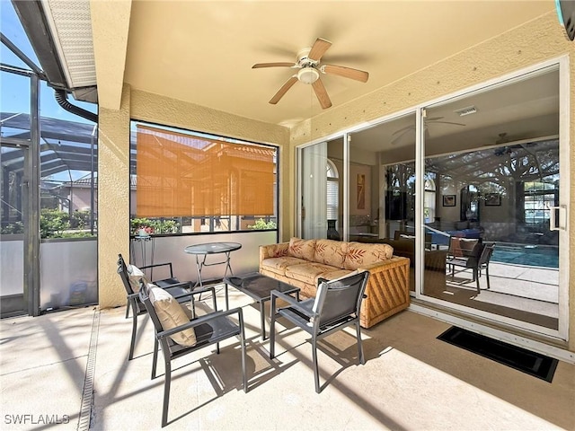 view of patio with visible vents, glass enclosure, an outdoor hangout area, and a ceiling fan