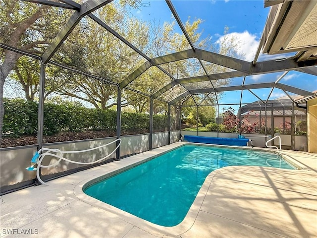 pool with glass enclosure and a patio