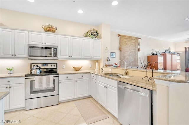 kitchen with a sink, white cabinetry, recessed lighting, stainless steel appliances, and a peninsula