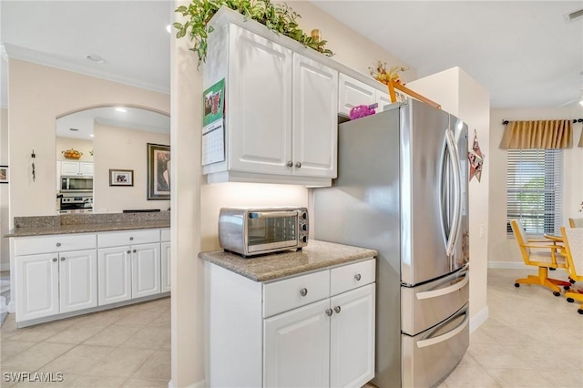 kitchen featuring visible vents, a toaster, arched walkways, stainless steel appliances, and white cabinets