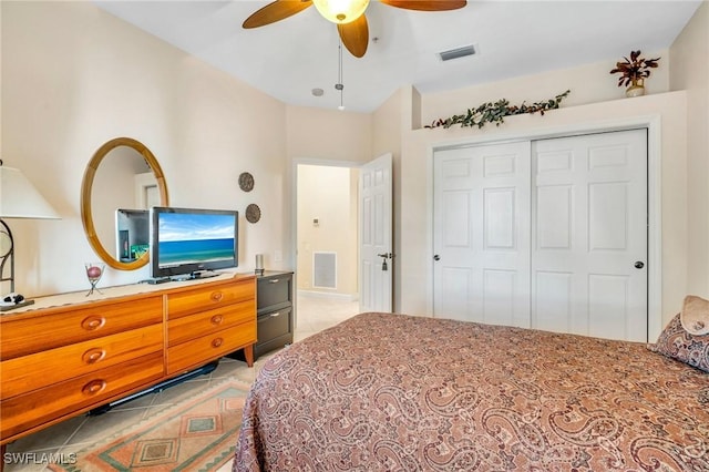 bedroom featuring light tile patterned floors, visible vents, a closet, and ceiling fan