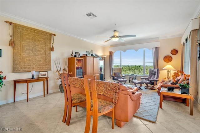 living room featuring visible vents, baseboards, crown molding, and a ceiling fan