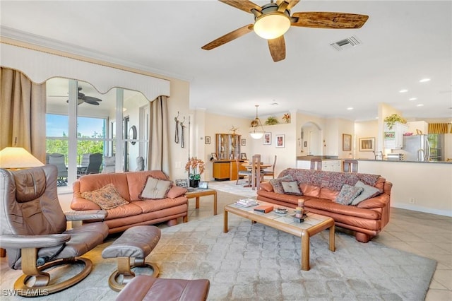 living room featuring light tile patterned floors, a ceiling fan, visible vents, and ornamental molding