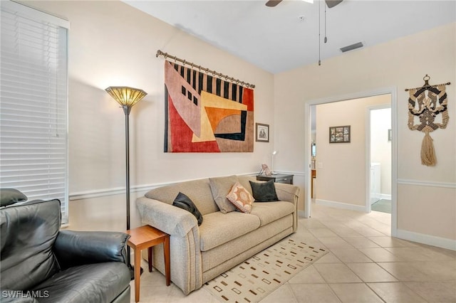 living area with light tile patterned floors, visible vents, baseboards, and ceiling fan