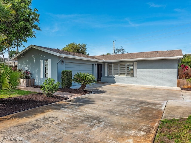 ranch-style house with an attached garage, fence, stucco siding, brick siding, and driveway