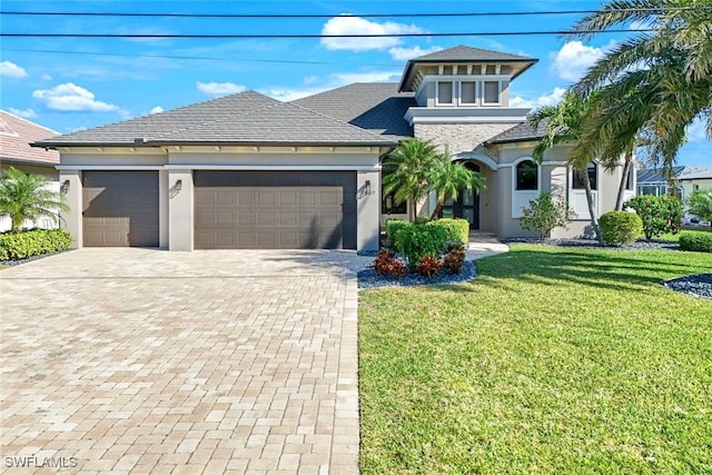 view of front of house featuring a front lawn, decorative driveway, and stucco siding