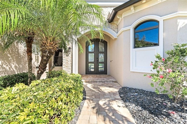 property entrance featuring french doors and stucco siding