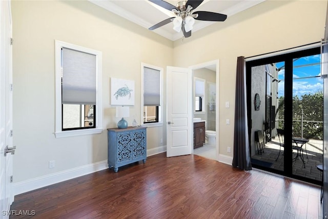 empty room with ceiling fan, crown molding, baseboards, and wood finished floors