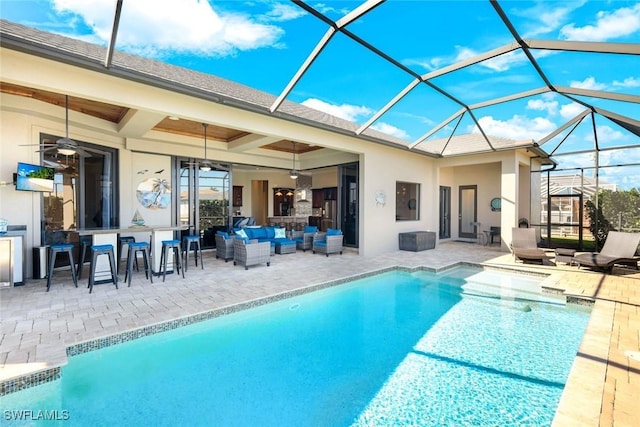 pool featuring glass enclosure, a patio, a ceiling fan, and an outdoor hangout area