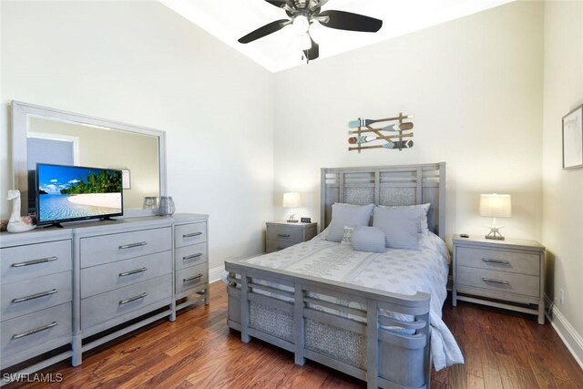 bedroom featuring baseboards, ceiling fan, dark wood-style flooring, and vaulted ceiling