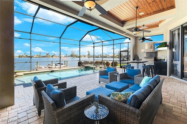 view of patio with glass enclosure, outdoor wet bar, area for grilling, a pool with connected hot tub, and outdoor lounge area