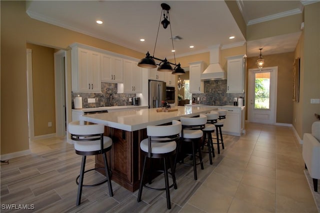 kitchen featuring a spacious island, stainless steel appliances, light countertops, custom range hood, and white cabinetry