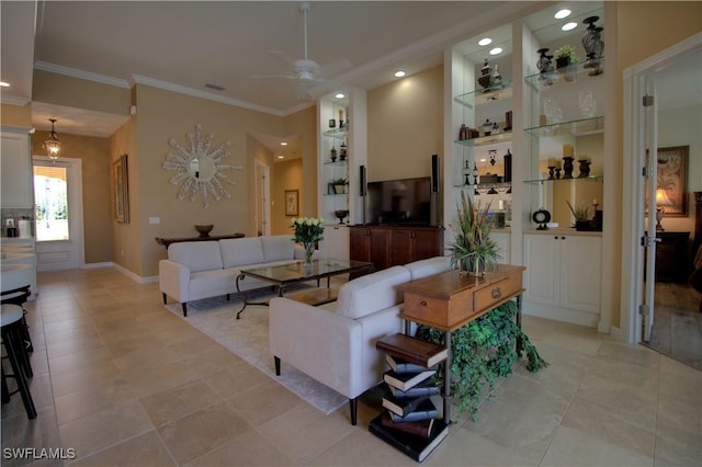 living room featuring built in shelves, baseboards, recessed lighting, ceiling fan, and crown molding