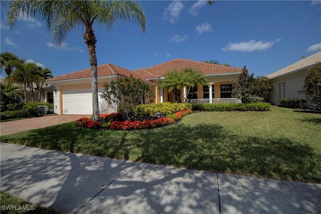 view of front of home featuring a garage, driveway, a front yard, and a tile roof