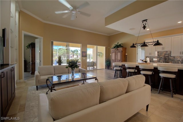 living area with crown molding and a ceiling fan