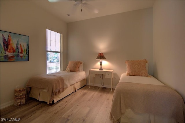 bedroom featuring a ceiling fan, light wood-type flooring, and baseboards