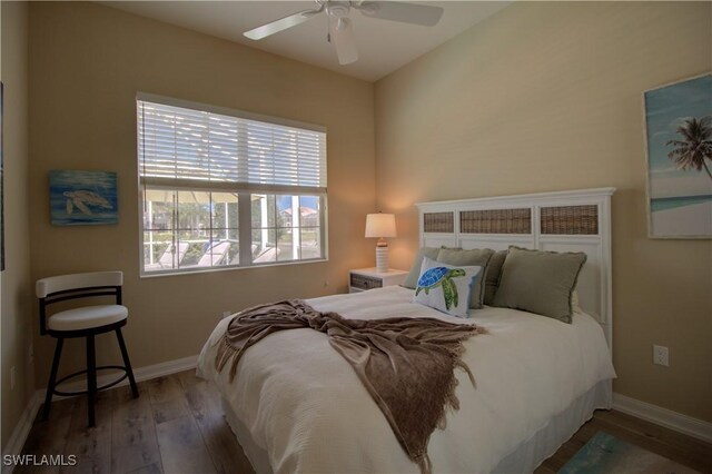 bedroom with wood finished floors, baseboards, and ceiling fan