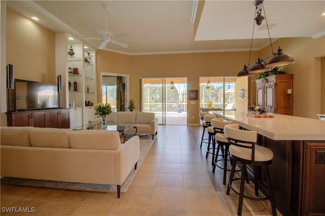 living area with light tile patterned flooring, ceiling fan, and crown molding