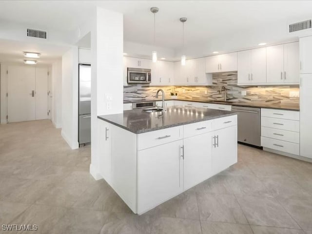 kitchen featuring a sink, white cabinets, visible vents, and stainless steel appliances