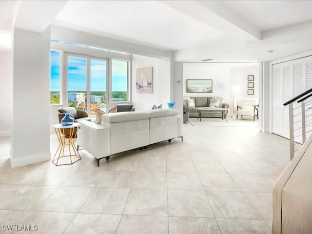 living area featuring light tile patterned flooring and baseboards