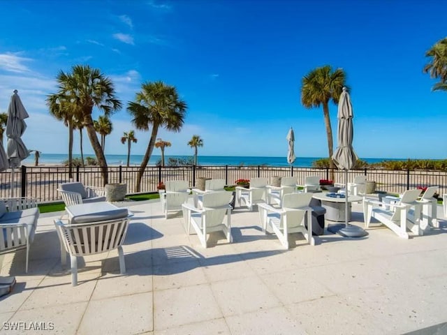 view of patio / terrace featuring a water view and fence